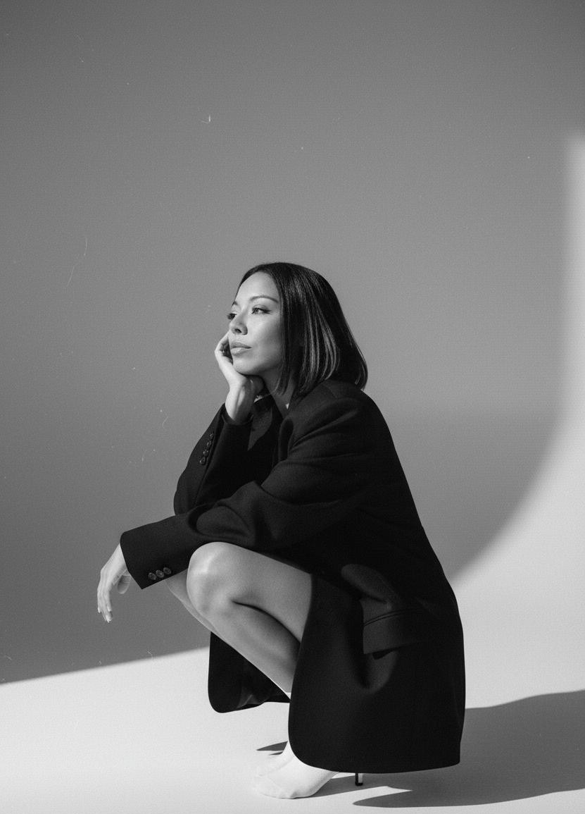 Retrato en blanco y negro de Monse sentada de perfil con americana negra